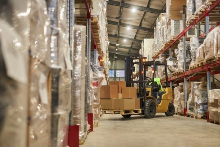 Background image of warehouse interior with forklift carrying boxes